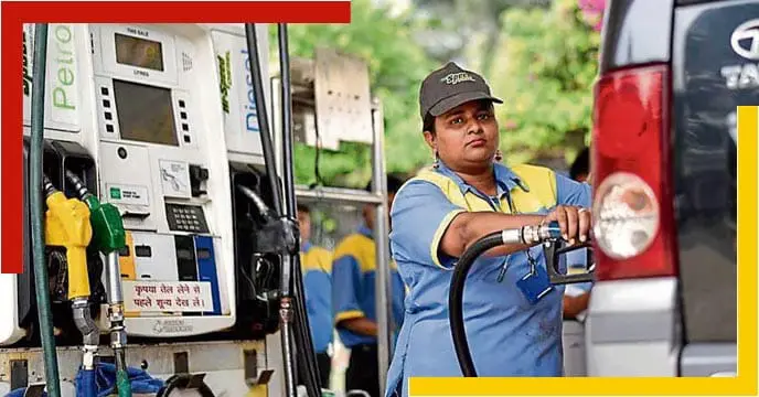 A petrol pump in India with fuel dispensers and vehicles parked in front.