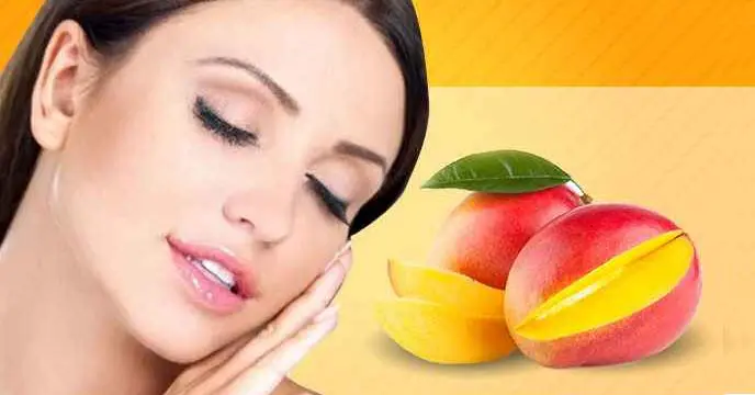 Woman holding a ripe mango, showcasing the skin benefits of mango in summer.