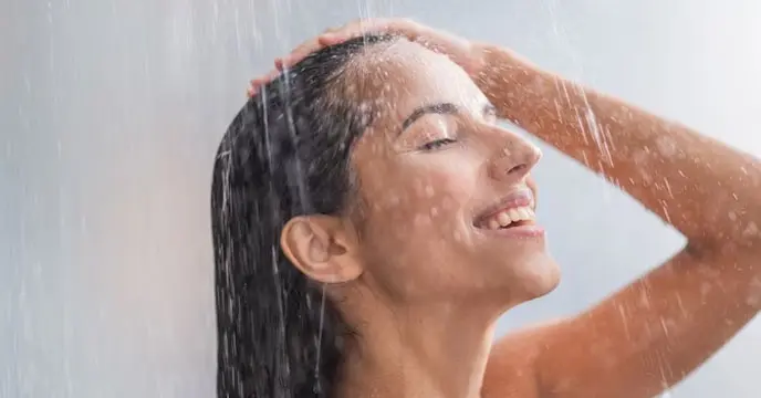 Woman bathing in hot water made using immersion rod