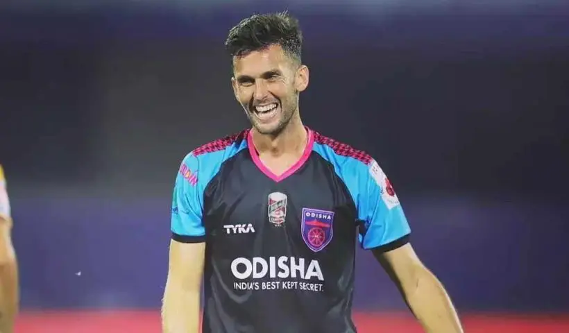 Portrait of Carlos Delgado, a man with short dark hair and a confident expression, wearing a dark suit and tie against a neutral background.