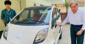 Ratan Tata sitting in a red Tata Nano Electric Vehicle