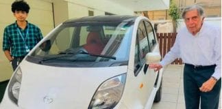 Ratan Tata sitting in a red Tata Nano Electric Vehicle