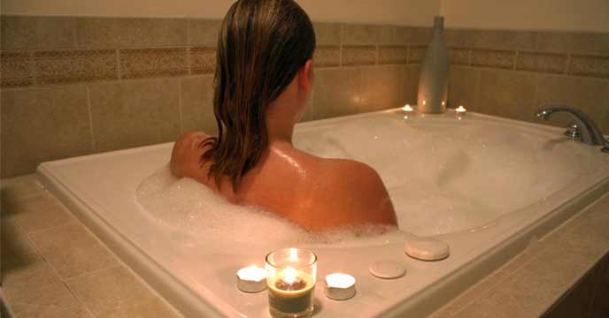 Girl using hot water to relieve back pain