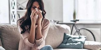 Woman sneezing after leaving an AC room