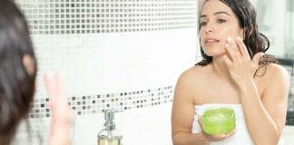 Woman applying Aloe Vera gel on sunburnt skin