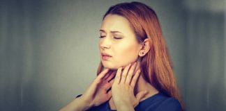 Woman holding her neck with a concerned expression due to thyroid issues