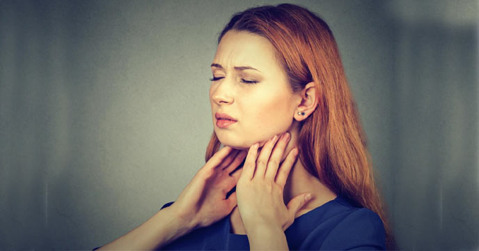 Woman holding her neck with a concerned expression due to thyroid issues