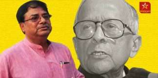 Udayan Guha pictured with a portrait of Jyoti Basu in the background