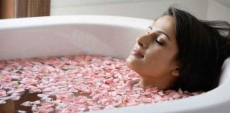 Indian girl pouring rose water into her bath