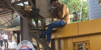 A man charging his mobile phone at a railway station in India