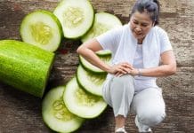 A bowl of fresh cucumbers on a wooden table