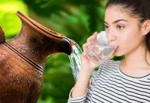 Young Indian girl drinking water from an earthen pitcher