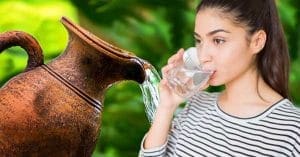 Young Indian girl drinking water from an earthen pitcher
