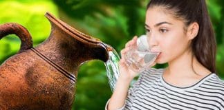 Young Indian girl drinking water from an earthen pitcher