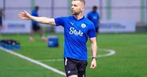 Image of Mumbai City FC Coach Petr Kratky, a man wearing a team tracksuit and cap, standing on a football field with a determined expression