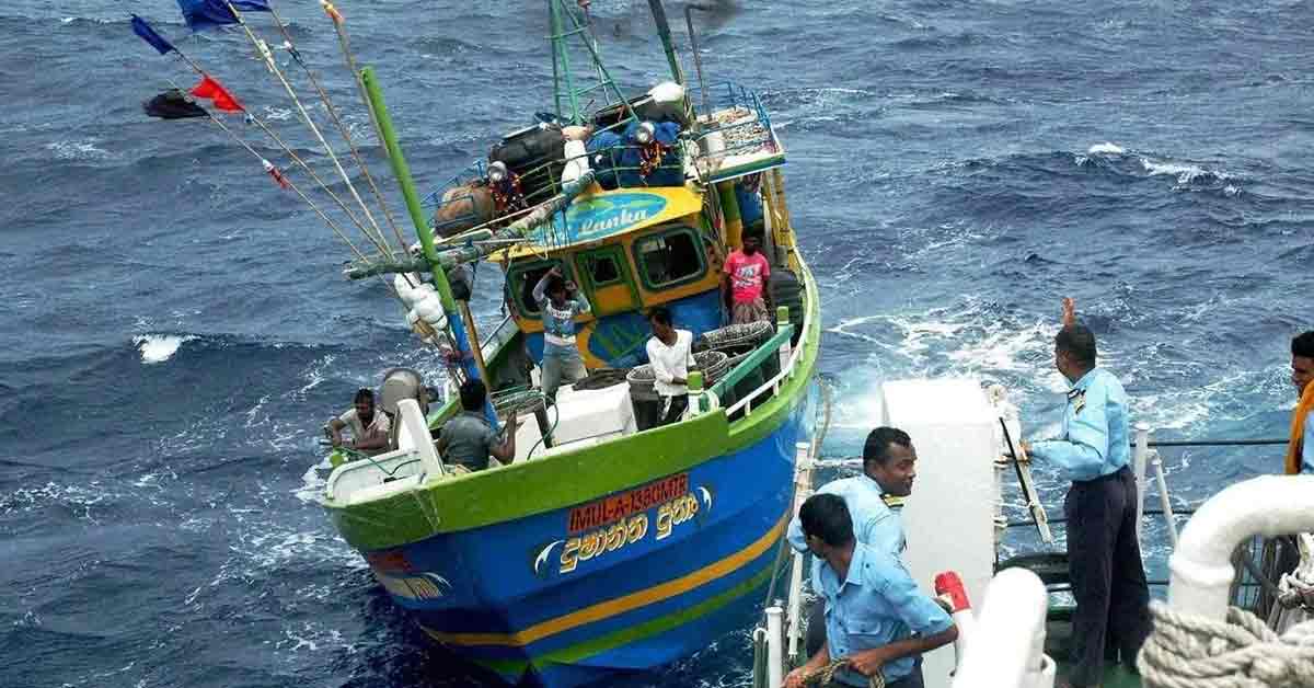 Image of Sri Lankan Navy personnel detaining Tamil Nadu fishermen, with two seized fishing boats in the background, following a reported apprehension incident.