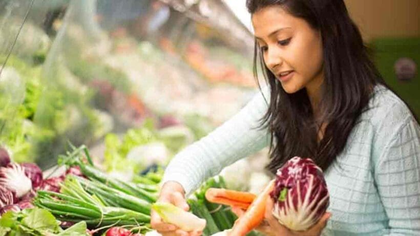 A variety of fresh vegetables arranged neatly on a surface. The assortment includes carrots, bell peppers, cucumbers, and tomatoes, showcasing vibrant colors and different shapes.