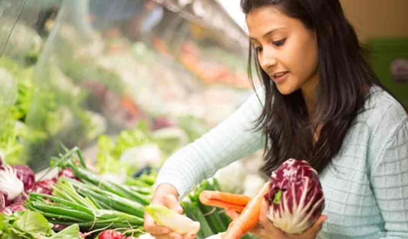 A variety of fresh vegetables arranged neatly on a surface. The assortment includes carrots, bell peppers, cucumbers, and tomatoes, showcasing vibrant colors and different shapes.