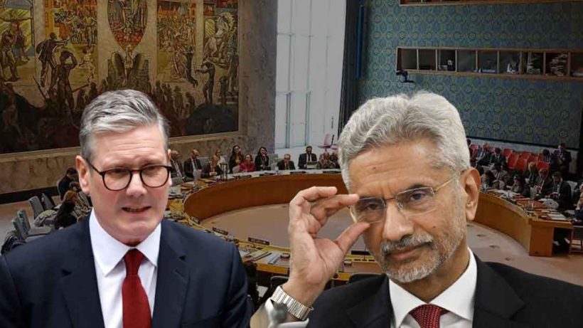 Indian External Affairs Minister S. Jaishankar standing with UK Prime Minister Rishi Sunak, both in formal attire, engaging in conversation against an official setting. Jaishankar is gesturing with his hand, while Sunak listens attentively, highlighting the diplomatic interaction between the two leaders