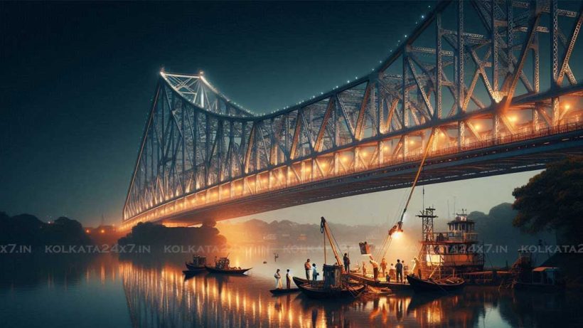 A view of the Howrah Bridge at night, with the bridge fully illuminated and reflecting off the water below. The bridge is closed to traffic, with workers performing a health check on the structure. The scene is peaceful and quiet, with the only sounds coming from the water below and the workers on the bridge