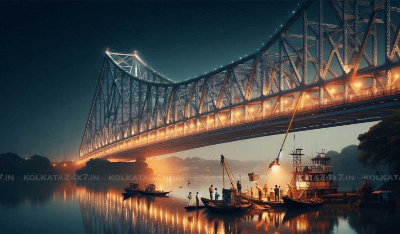 A view of the Howrah Bridge at night, with the bridge fully illuminated and reflecting off the water below. The bridge is closed to traffic, with workers performing a health check on the structure. The scene is peaceful and quiet, with the only sounds coming from the water below and the workers on the bridge